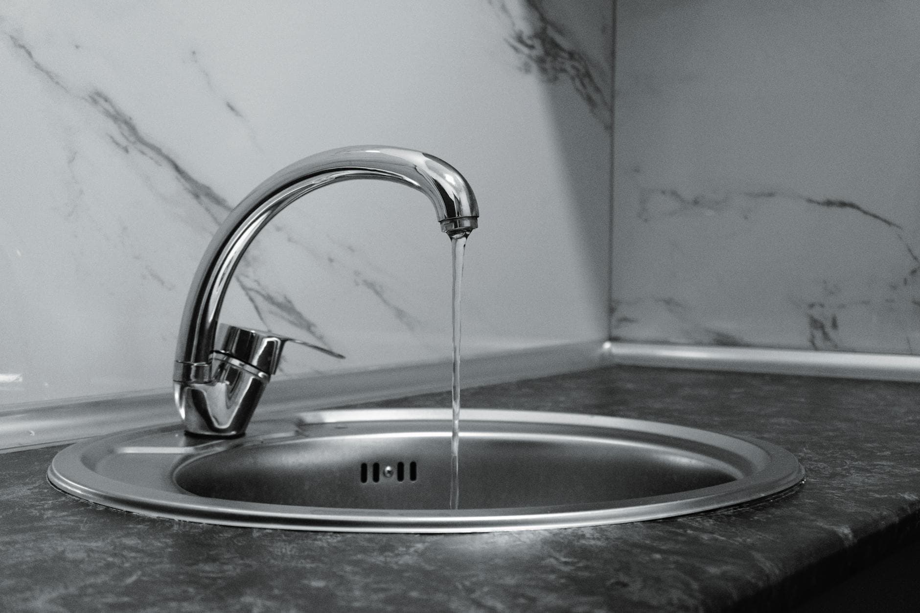 Clean kitchen faucet with running water in a modern residential kitchen